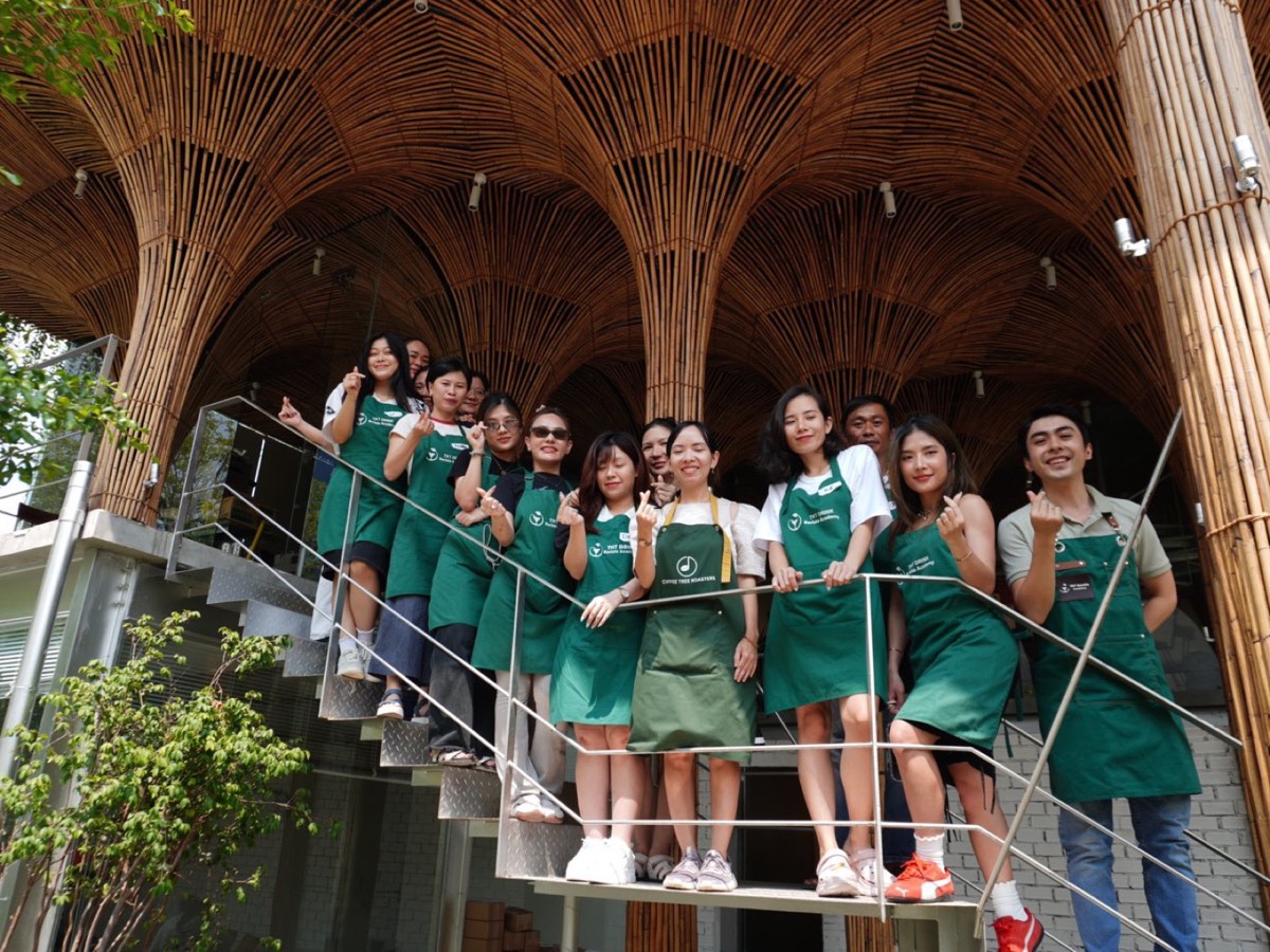Học viên TNT Barista Academy mặc tạp dề chụp ảnh tại cầu thang quán Coffee Tree Roasters